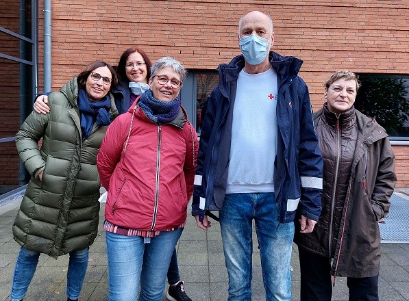 Mehrere Menschen stehen zusammen und lächeln