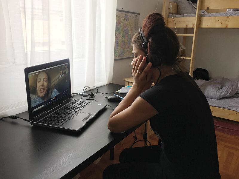 O fată învață online, alături de voluntari.