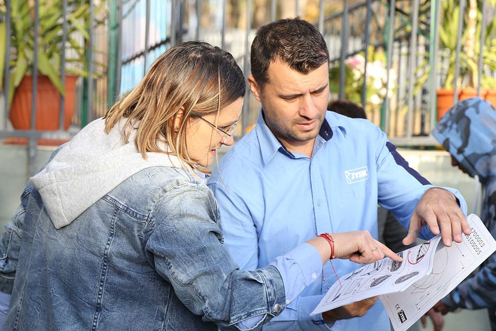 Marinela și Liviu verifică instrucțiunile de montare a trambulinei