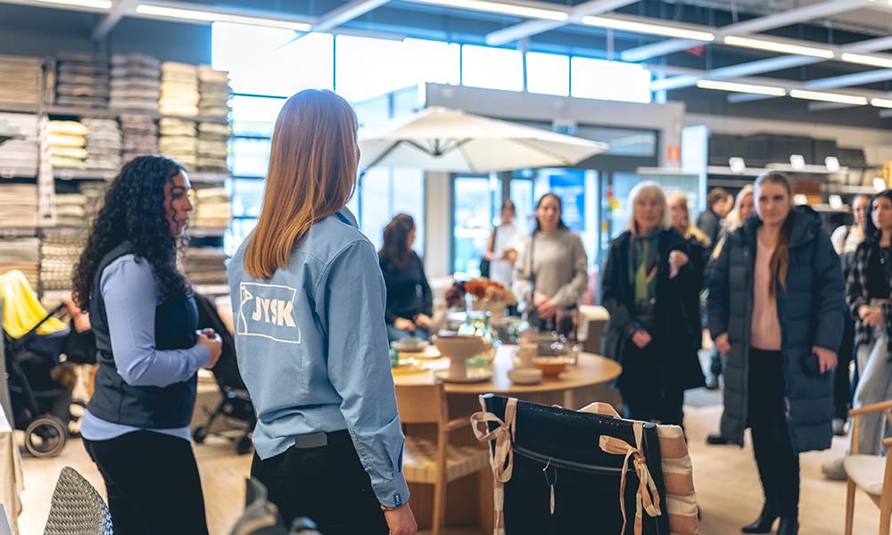 Influencers och journalister står i en samling och lyssnar till JYSKs Ronja Ali och Sandra Martinsson.