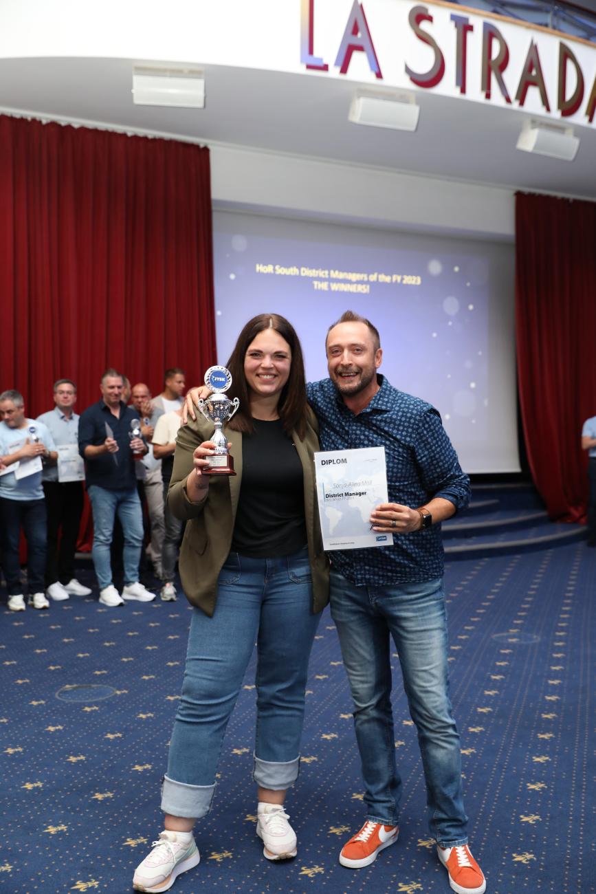 Titel erfolgreich verteidigt: Sonja-Alina (links) aus Region 11 ließ sich gebührend von Retail Manager Steve (rechts) feiern. 