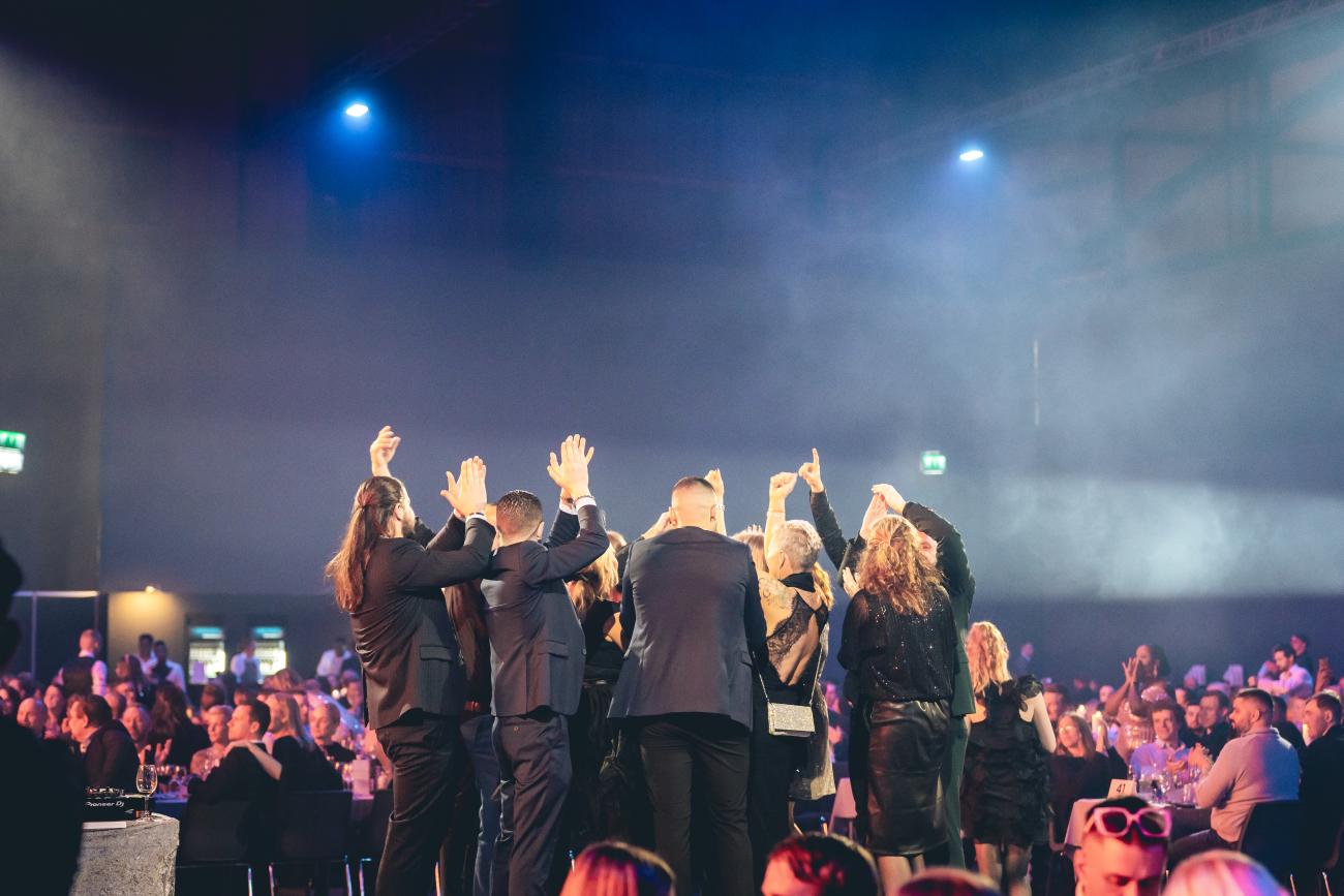En grupp JYSK-medarbetare dansar på scenen mitt i lokalen. Foto: Joakim Thörne.