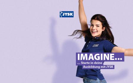 Eine junge Frau mit langen Haaren lächelt in die Kamera. Vor ihr ist der Schriftzug "Imagine" zu lesen