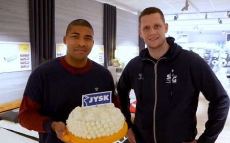 Zwei Männer stehen mit einem Kuchen im Matratzenstudio