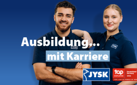 Ein junger Mann und eine junge Frau lächeln in die Kamera. Beide tragen JYSK-Poloshirts. Die Frau stützt ihren Arm lässig auf der Schulter des Mannes ab.